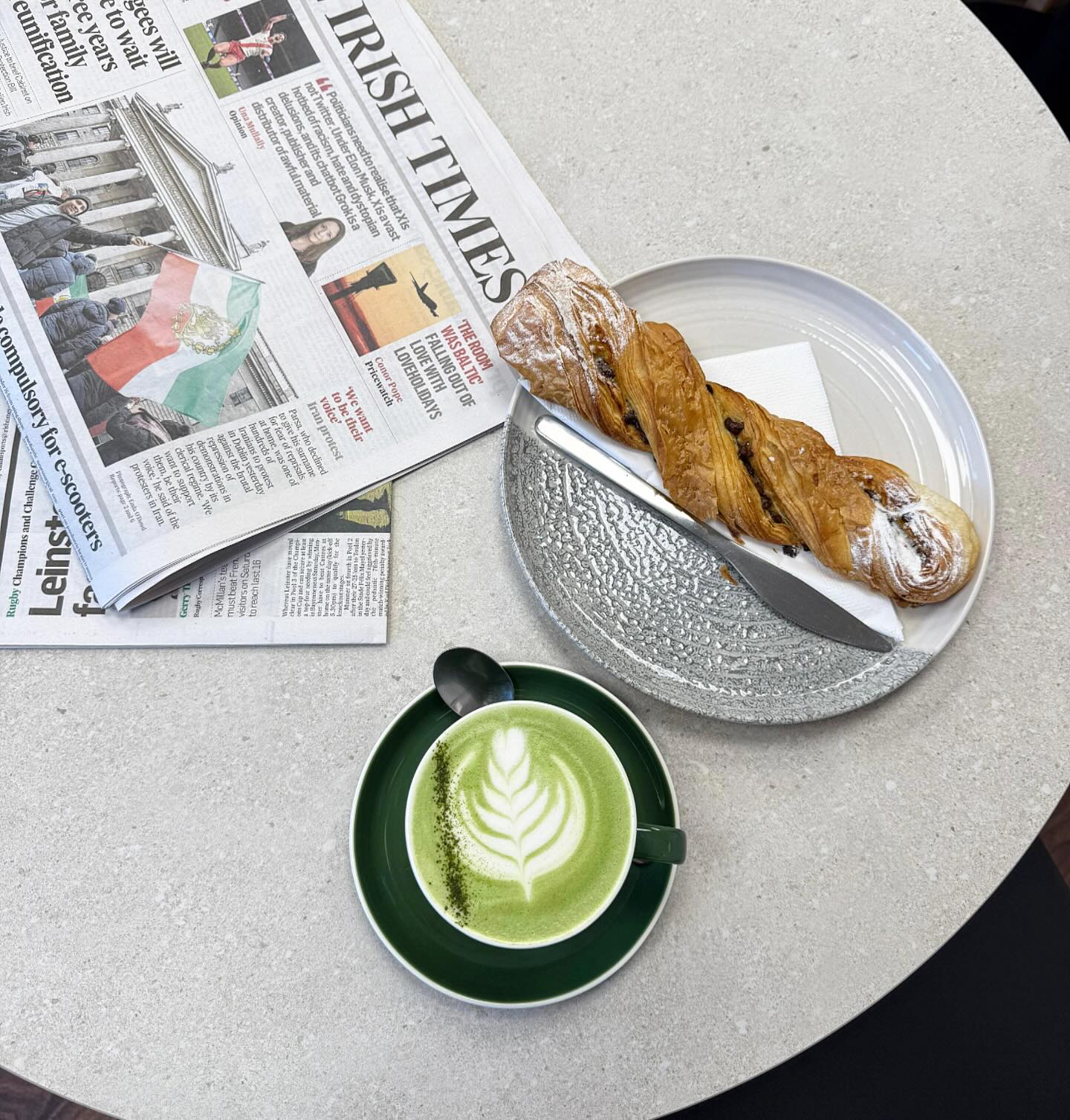 Matcha latte beside the Irish Times, overhead